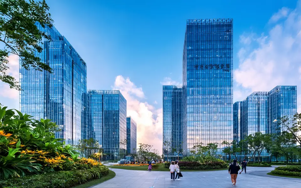 写实摄影，成都天府软件园现代化的玻璃幕墙建筑群，前景有绿植和行人，背景是蓝天白云，暖色调，广角构图，体现科技与生态融合